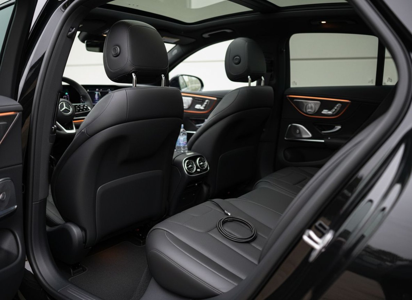 Rear cabin of the Mercedes-Benz EQE with ambient lighting, water and phone charging